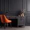 Home workplace with wooden drawer writing desk and orange chair near black wall with wainscoting
