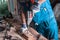 Home workshop. A man Builder in overalls and gloves drills a wooden Board close-up.