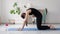 Home yoga, woman make cat cow pose on mat in living room. 20s slim female in sportswear