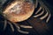 Homebaked bread. Loaf of round peasant bread and spikelets of wheat on a wooden background. Homemade baking