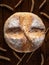 Homebaked bread. Top view of a loaf of round peasant bread and spikelets of wheat on a wooden background