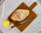 Homebread. Home made bread on wooden cutting board with knife and porcelain ramekin with butter on the side in top view