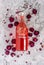 Homebrew rose Kombucha in swing top glass bottle with dried rose buds on white table background.