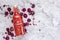 Homebrew rose Kombucha in swing top glass bottle with dried rose buds on white table background.