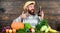 Homegrown organic food. Man with beard wooden background. Organic horticulture concept. Farmer with organic vegetables