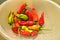 Homegrown red, orange, and green small hot chili peppers spicy vegetable ingredient for cooking