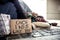 Homeless beggar man lying on the ground outdoors in city, sleeping.