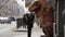 Homeless child talking to man in t rex mascot costume at sidewalk