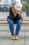 Homeless dejected woman sitting on a city bench