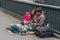 Homeless family sitting on the street