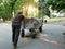 A homeless man pushes a cart in front of him