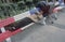 Homeless man sleeping on red, white and blue bench, New Jersey City