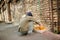 Homeless man squating to wash hands.