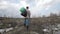 Homeless man standing on garbage hill at dump site