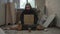 Homeless poor man sitting in a room of an abandoned building. He is holding a piece of cardboard, 'I didn't