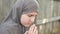 Homeless refugee teen girl prays, holds her hands in front of her