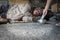 Homeless senior man with gray beard and grey hair with wearing sweater and blanket sleeping the sidewalk