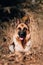 Homely cute dog on a walk in the Park. German shepherd black and red color lies in the yellow autumn forest and smiles. Beautiful