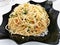Homemade aglio olio pasta in a black plate. Italian dish