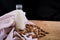 Homemade almond milk in glass bootle with oatmeal cookies on the wooden table. Organic alternative milk. Copy space. Cookies with