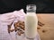 Homemade almond milk in glass bootle with oatmeal cookies on the wooden table. Organic alternative milk. Copy space. Cookies with