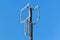 A homemade antenna in the form of a rectangular screen of aluminum wire is tied to a wooden pole against a blue sky on a winter