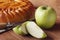 Homemade apple cake and green apple over natural wood background