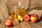 Homemade apple juice with ice, red apples, straw, still life on a wooden table