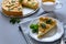 Homemade apple pie with cheese decorated mint leaves on gray wooden background. Teatime or vegetarian food concept. Selective