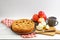 Homemade apple pie with lattice, apples and cup of tea on white wooden table. Angle view.