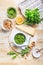 Homemade arugula pesto with ingredients on wooden background