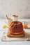 Homemade autumn carrot cake with candied fruits on wooden cutting board and cup of tea