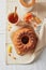 Homemade autumn carrot cake with candied fruits on wooden cutting board and cup of tea