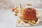 Homemade autumn carrot or pumpkin bundt cake with candied fruits, cup of tea and golden decorative pumpkins on light background
