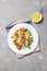 Homemade autumn healthy salad with quinoa, salad leaves, tomatoes, pumpkin and feta cheese on a white plate