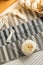 Homemade baked bakery or dessert, a white bun place on a cooling rack on striped placemat and some ingredients