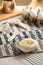 Homemade baked bakery or dessert, a white bun place on a cooling rack on striped placemat and some ingredients