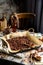 Homemade baked chocolate granola with nuts, oat flakes on baking tray with parchment stands on grey wooden table