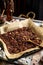 Homemade baked chocolate granola with nuts, oat flakes on baking tray with parchment stands on grey wooden table