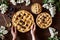 Homemade bakery pastry apple pies on dark wooden kitchen table with raisins, blueberry, honey and apples. Traditional