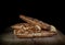 Homemade baking triangular pies with toppings on wooden board on black background