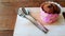 Homemade banana cupcake with pink beautiful cover, spoon and fork on the wooden plate with copy space