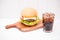 Homemade BBQ burger with coke on wooden background.