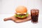 Homemade BBQ burger with coke on wooden background.