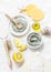 Homemade beauty facial mask. Clay, lemon, oil, facial brush - beauty products ingredients on light background