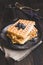 Homemade belgian waffles with blueberries on the dark wooden tab