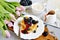 Homemade Belgian Waffles with Cream Sauce Berries, Cup with Cappuccino Beverage Flowers Pink Tulips, Gray Background Table Kitchen