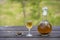 Homemade birch buds tincture in a glass bottle and a wine crystal glass on a wooden table