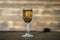 Homemade birch buds tincture in a wine crystal glass on a wooden table background