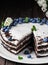 Homemade bird cherry cake with sour cream, decorated with blueberries and mint leaves on baking paper. Closeup